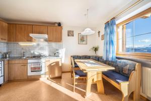 a kitchen and dining room with a table and a couch at Stücklhof Wohnung Rose in San Genesio Atesino +28 photos
