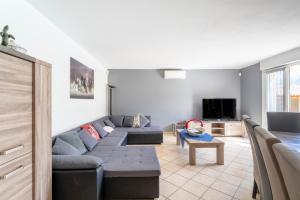 a living room with a couch and a tv at Gîte les oliviers in Saint-Laurent-la-Vernède