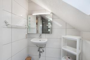 ザンクト・ブラージエンにあるSchwarzwaldglück Loftの洗面台と鏡のある白いバスルーム +16枚の写真