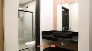 uma casa de banho com um lavatório preto e um WC. em Studio em Bauru no Centro da Cidade em Bauru