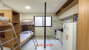 Habitación pequeña con literas y nevera. en Studio em Bauru no Centro da Cidade, en Bauru