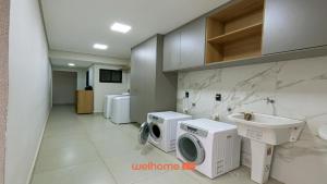 lavadero con lavadora y fregadero en Studio em Bauru no Centro da Cidade, en Bauru 1 foto más