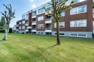 an apartment building with two trees in front of it at Wellness Ferienwohnung Strandperle in Cuxhaven