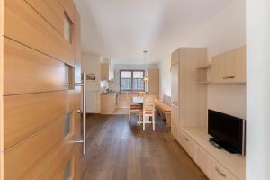 a kitchen with wooden cabinets and a dining room at Wohnung Deluxe Obertrisaierhof in Fie allo Sciliar