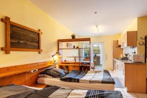 two beds in a room with a kitchen at App und Fewos Wolf in Usingen