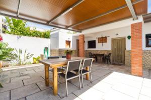 an outdoor patio with a wooden table and chairs at Casa Basallote in El Palmar