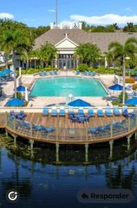 einen Pool mit Stühlen und Sonnenschirmen vor einem Resort in der Unterkunft Luxury house in Disney in Kissimmee