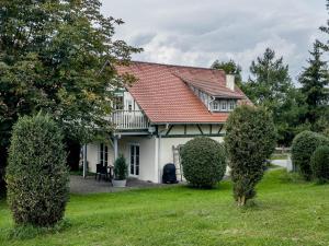 ein weißes Haus mit rotem Dach und einigen Büschen in der Unterkunft Schnyder Ranch in Ravensburg