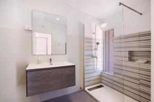une salle de bain avec un lavabo et une douche dans l'établissement Villa Lynn - Quadradinhos, à Almancil 19 autres photos