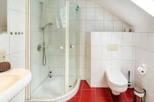Un baño con ducha, inodoro y lavabo. en Ferienhaus Lüttje Dörp, en Blomberg 30 fotos más