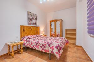 een kleine slaapkamer met een bed en een tafel bij Apartamentos Haza La Moraleda 2 y A in Güéjar-Sierra