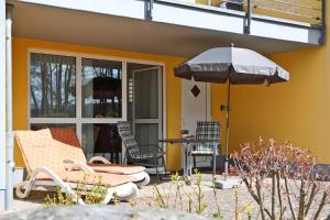 JabelFerienwohnung Maribell Jabel的带遮阳伞、桌椅的露台