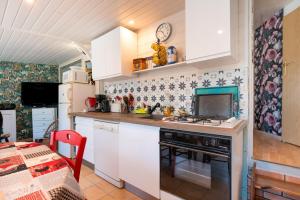 Una cocina con gabinetes blancos y un horno de estufa. en Mobilhome rénové Sarzeau, en Sarzeau