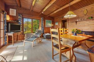 バート・ガンダースハイムにあるHaus-am-Harz Bad Gandersheimのテーブルと椅子とテレビのあるリビングルーム