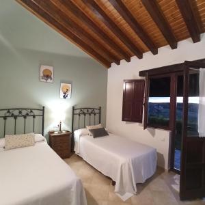 a bedroom with two beds and a window at Las Candelas - La Canaleja in Oreña