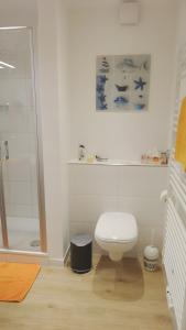 ボルクムにあるFerienwohnung Borknaのトイレとシャワー付きの白いバスルーム +8枚の写真