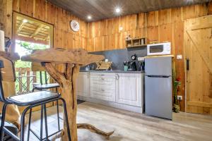 a kitchen with wooden walls and a white refrigerator at La cabane de Gardelac in Saint-Rémy +16 photos