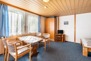 Una habitación con una mesa y sillas y un televisor. en Bungalow 21 - Kimbucht, en Reichendorf