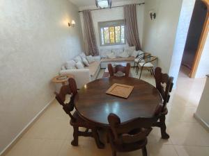 a dining room with a table and a living room at Le Coin Nature in Azrou