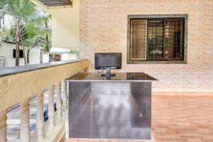 a television sitting on a counter in a room at Hotel O Nisarg Resort Satpati Beach in Satpati