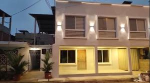 Una casa blanca con luces por la noche. en Amathea Imperial, en Machala