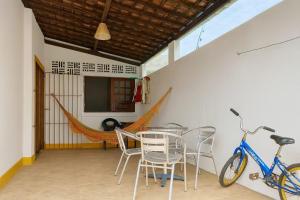 a room with a table and chairs and a bike at Casa Maré Alta – Piscina e Sossego em Tabuba in Santa Luzia