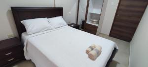 Un dormitorio con una cama con un par de zapatillas. en Amathea Imperial, en Machala