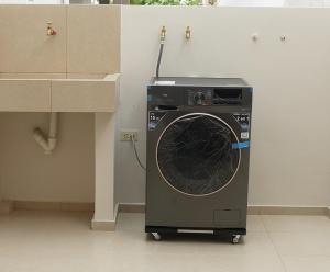 Una lavadora en un carrito en una habitación. en Amathea Imperial, en Machala