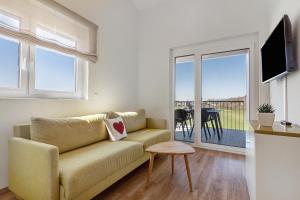 ヘルボルツハイムにあるGästehaus Heimeligのソファとバルコニーのあるリビングルーム