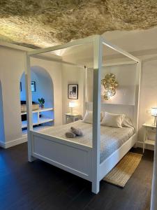 a bedroom with a white canopy bed with two tables at Avalon in Setenil in Setenil +82 photos