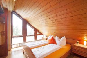 ヴァッサーブルクにあるFerienwohnungen Merkleの木製の天井の客室のベッド1台分です。