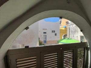 an arched window with a view of a building at L'angolo Fiorito in Ugento