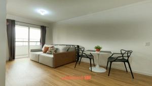 una sala de estar con un sofá y una mesa en Apartamento em Bauru em Frente ao Aeroporto, en Bauru