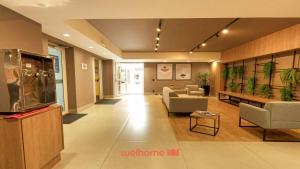 Apartamento em Bauru em Frente ao Aeroporto في Bauru: ردهة بها أرائك وكراسي في مبنى