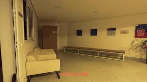 Apartamento em Bauru em Frente ao Aeroporto في Bauru: غرفة انتظار مع كرسي في مبنى