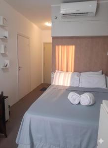 a bedroom with a bed with two towels on it at O Melhor Apart-Hotel, da Cidade! in São Caetano do Sul +30 photos