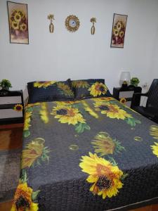 Una cama con una colcha con girasoles encima. en Casa Sunflower, en Puerto Jiménez