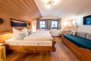 a bedroom with a large bed and a couch at Ferienwohnungen Isarwinkel in Krün