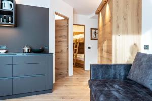 a living room with a blue couch and a kitchen at Apartment Bullaccia Stlarida in Ortisei