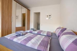 2 camas en una habitación con rayas púrpura y blanca en Ferienwohnung Schliestädt-Görge, en Lindau 18 fotos más