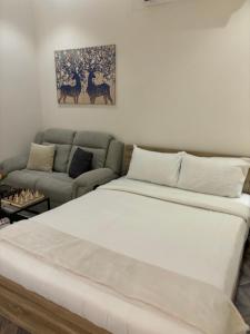 a white bed in a room with a couch at الكهوف النجدية حي الوزارات 3 in Riyadh