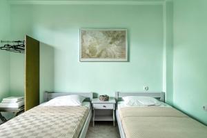 Dos camas en una habitación con paredes azules. en Old Boat double studio 6, en Nikiana