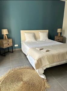 a bedroom with a large bed with a blue wall at Villa De Charme T3 Saint Florent in Barbaggio