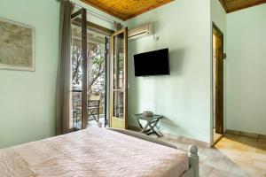 Un dormitorio con una cama y un televisor en la pared. en Old Boat double studio 9, en Nikiana