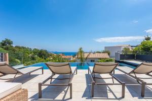 a patio with chairs and a swimming pool at Villa Belenos Piscine vue mer in Saint-Peïre-sur-Mer