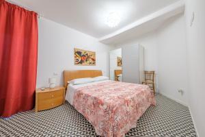 ein Schlafzimmer mit einem Bett und einem roten Vorhang in der Unterkunft I Mezzanini - Palazzo Bonaccorsi in Milazzo