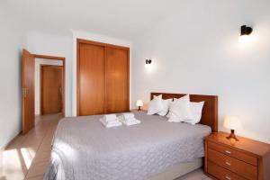 a bedroom with a bed with two towels on it at T1 Apartamentos Vista Alegre in Albufeira +17 photos