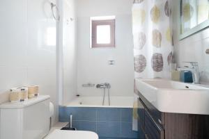 a bathroom with a toilet and a sink and a tub at Theodoros apartments in Nikiana +36 photos