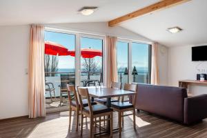 a dining room with a table and chairs and windows at Gästehaus D i c k r e i t e r in Immenstaad am Bodensee