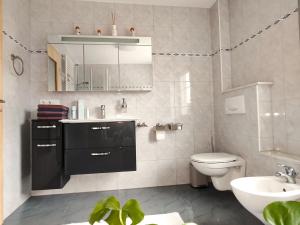 a bathroom with a sink and a toilet and a mirror at Grand Westfalia in Lotte +30 photos